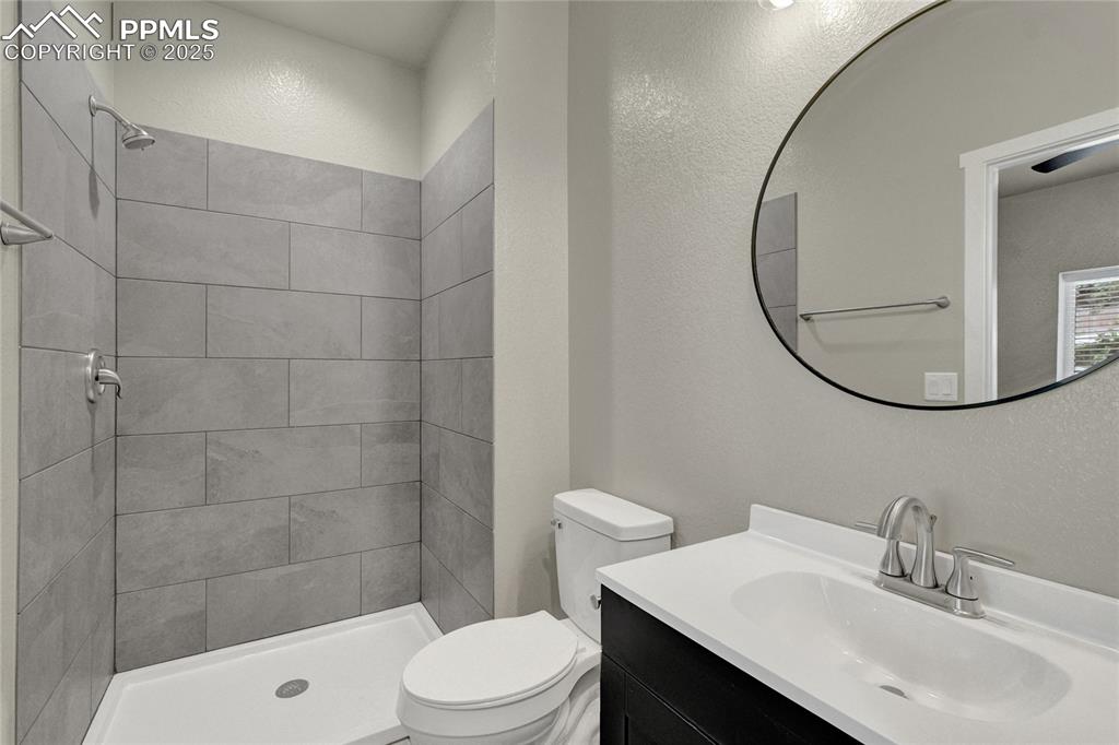 Image 13 of 38: Bathroom featuring vanity, a shower stall, and a textured wall