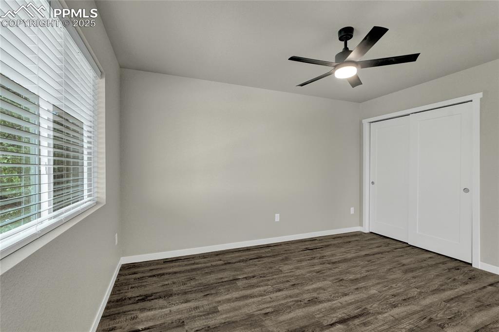 Image 20 of 38: edroom with dark wood-style flooring, ceiling fan, and a closet
