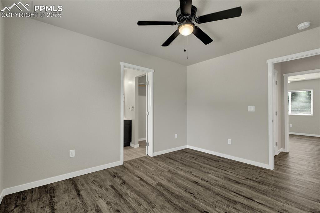Image 24 of 38: Spare room with dark wood finished floors and ceiling fan