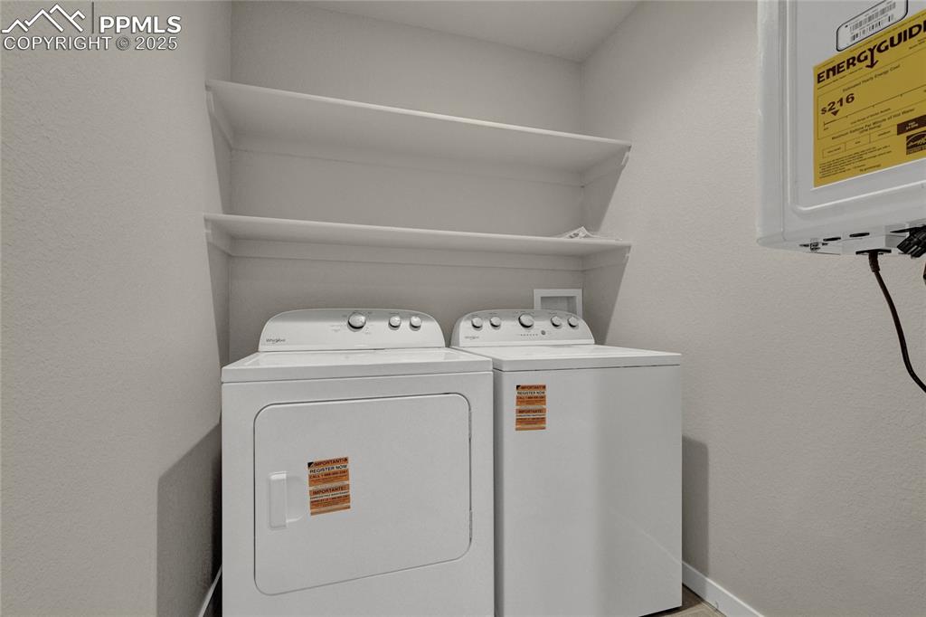Image 27 of 38: Washroom featuring a textured wall and washing machine and clothes dryer
