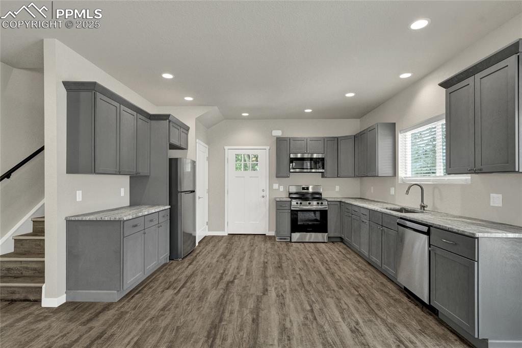 Image 3 of 38: Kitchen with gray cabinetry, appliances with stainless steel finishes, dark