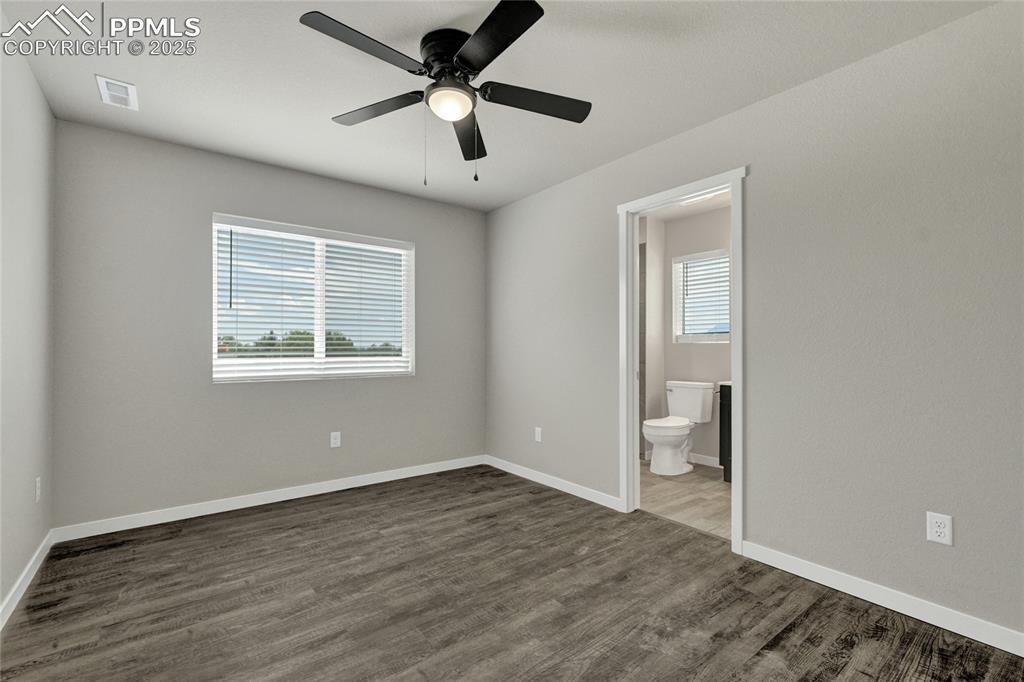 Image 32 of 38: Bedroom featuring multiple windows, dark wood-style floors, ceiling fan, an
