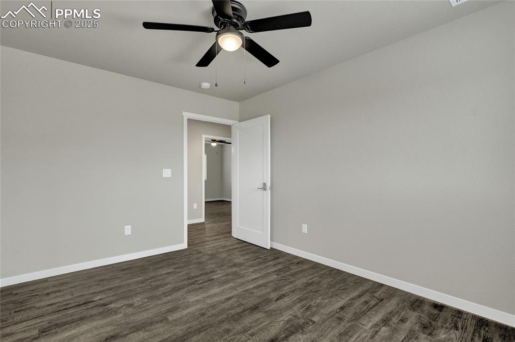 Image 33 of 38: Bedroom featuring a ceiling fan and dark wood-style flooring