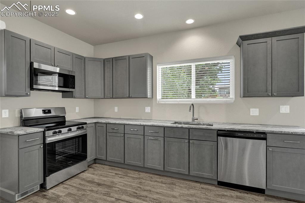 Image 4 of 38: Kitchen with gray cabinets, appliances with stainless steel finishes, light