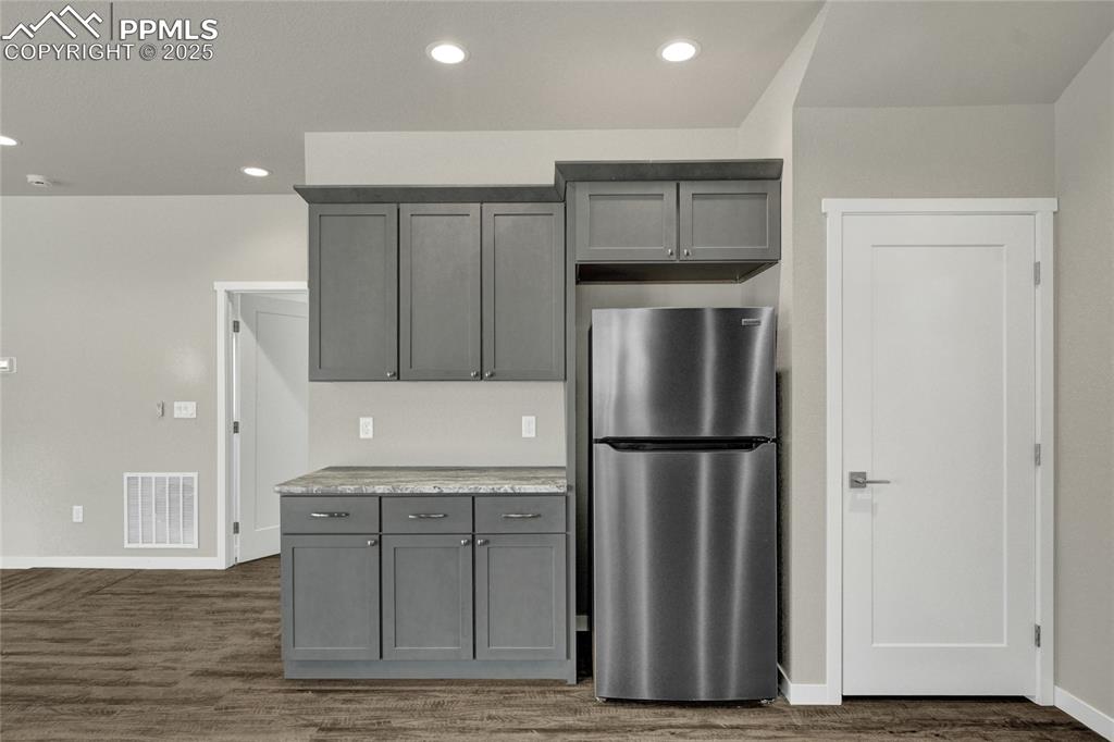 Image 7 of 38: Kitchen with freestanding refrigerator, gray cabinetry, recessed lighting, 