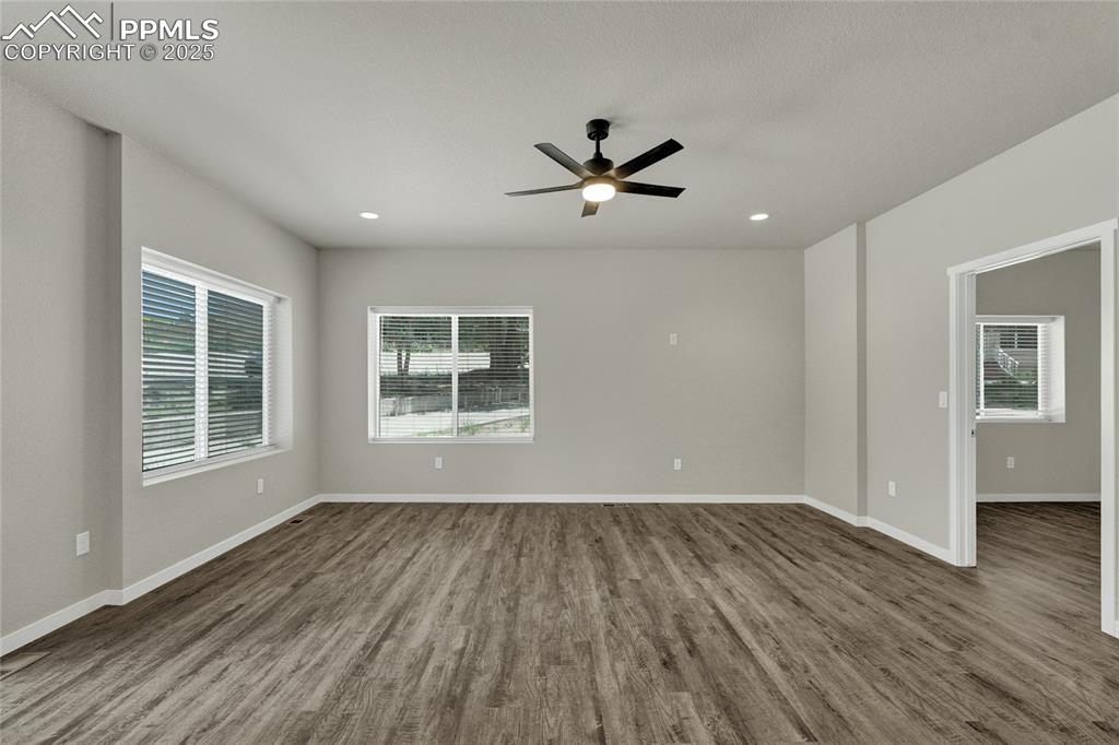 Image 8 of 38: Empty room with dark wood-style flooring, ceiling fan, and recessed lightin