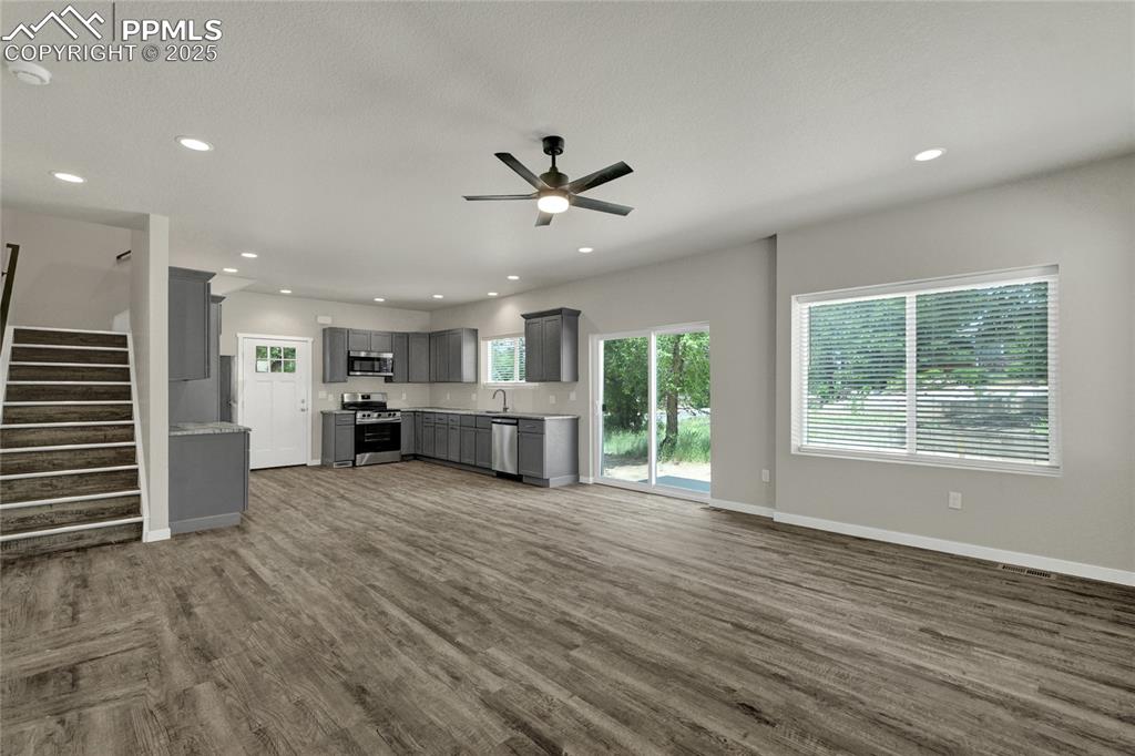 Image 9 of 38: Living room with stairway, dark wood-style flooring, ceiling fan, and reces