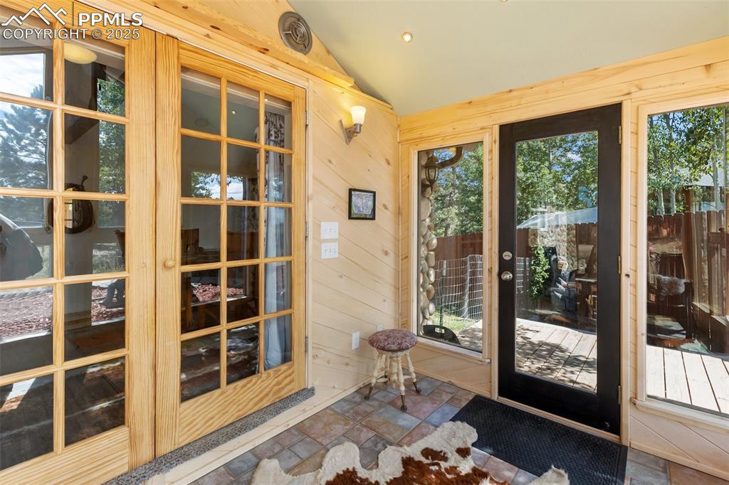 Image 10 of 44: Sunroom entry with french doors into main level.