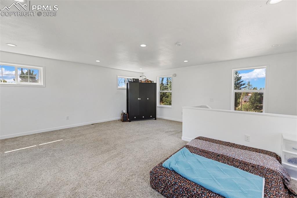 Image 35 of 44: Nonconforming bedroom on upper level with closet cabinet.