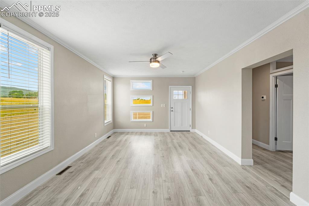 Image 13 of 44: Entryway featuring light wood-type flooring, a ceiling fan, and ornamental