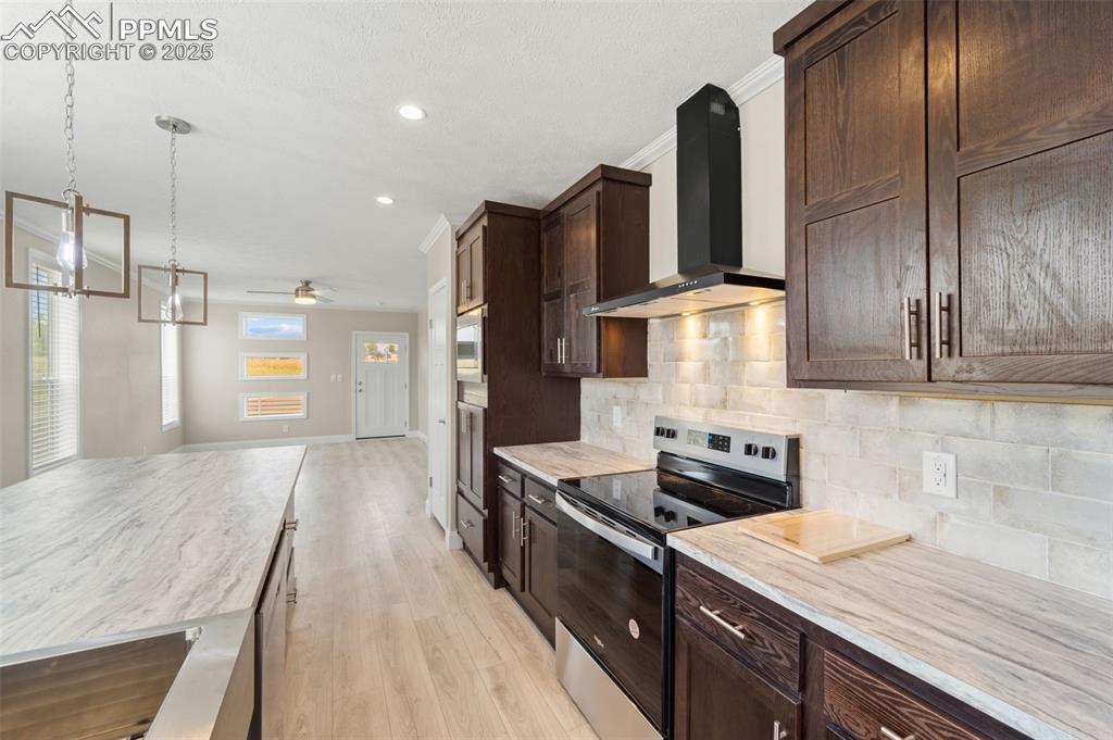 Image 18 of 44: Kitchen featuring stainless steel appliances, wall chimney exhaust hood, da