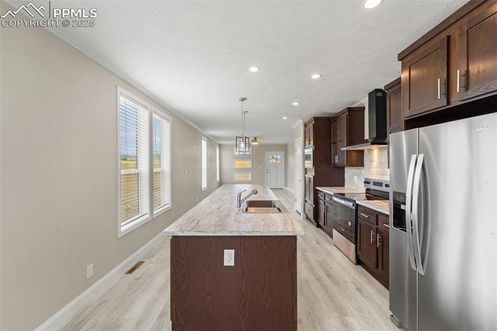 Image 20 of 44: Kitchen with stainless steel appliances, wall chimney range hood, crown mol