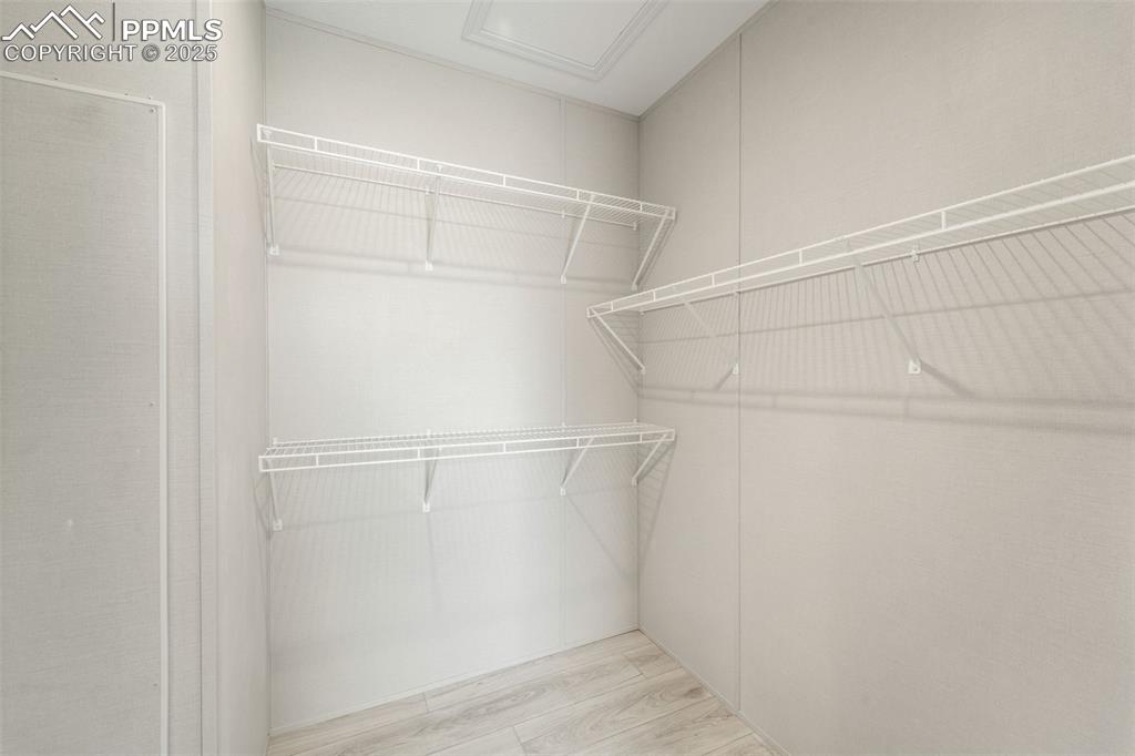 Image 24 of 44: Walk in closet with wood finished floors