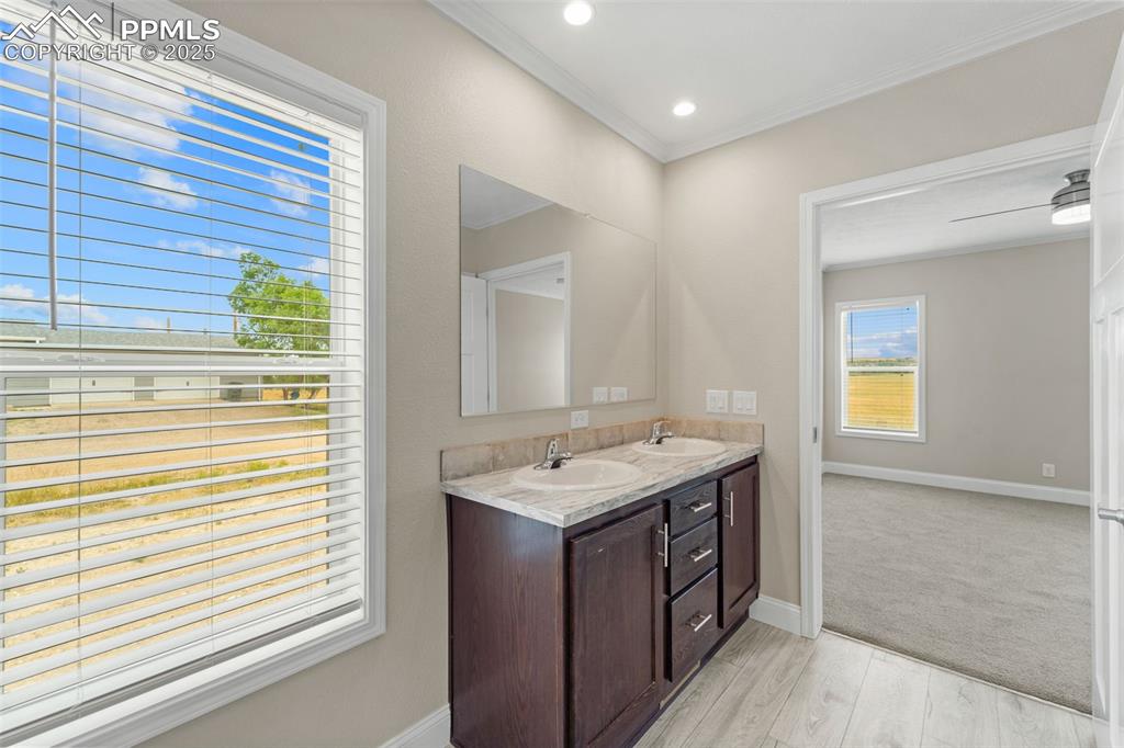 Image 26 of 44: Full bath featuring double vanity, crown molding, and wood finished floors