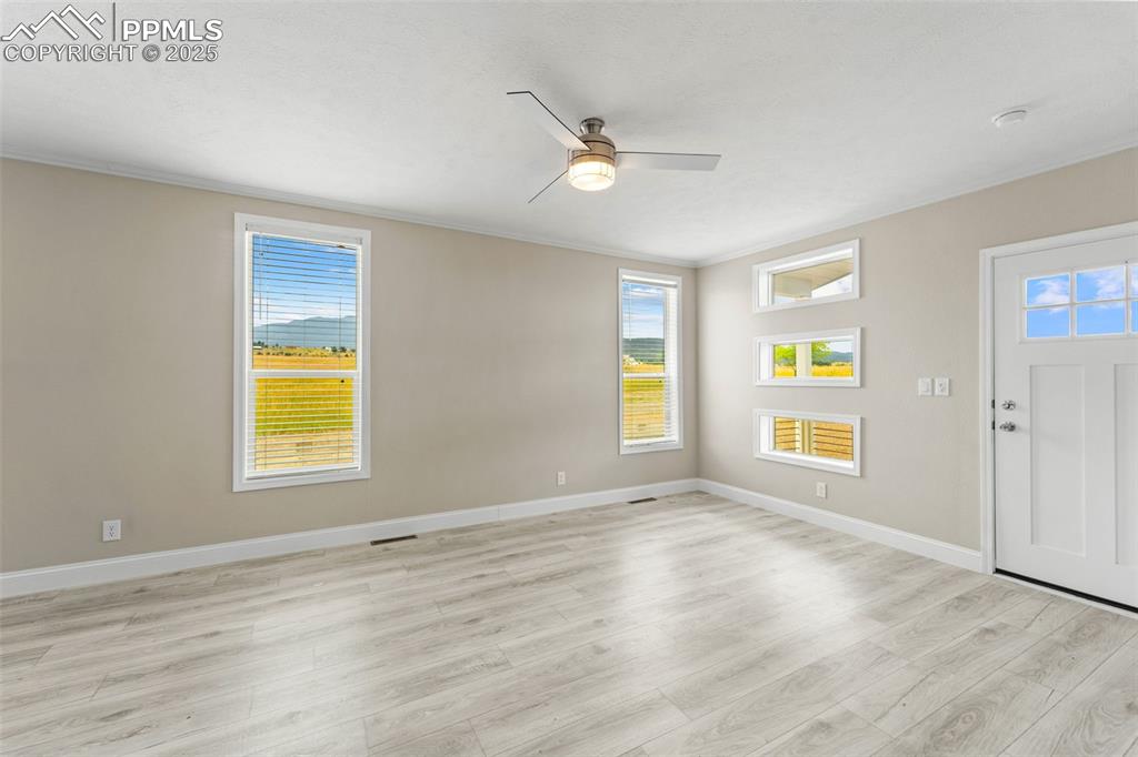 Image 31 of 44: Entrance foyer featuring light wood-type flooring, a ceiling fan, crown mol