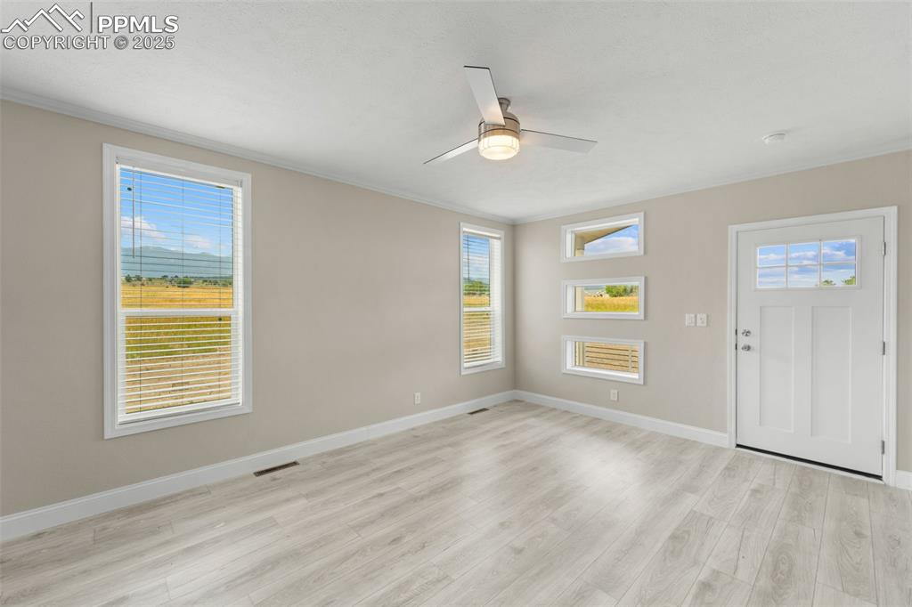 Image 32 of 44: Entryway featuring ceiling fan, light wood-type flooring, and ornamental mo