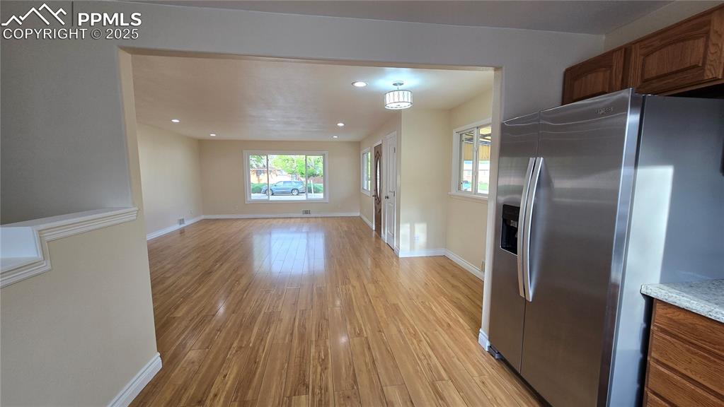 Image 11 of 42: Kitchen with stainless steel fridge with ice dispenser, light wood-style fl