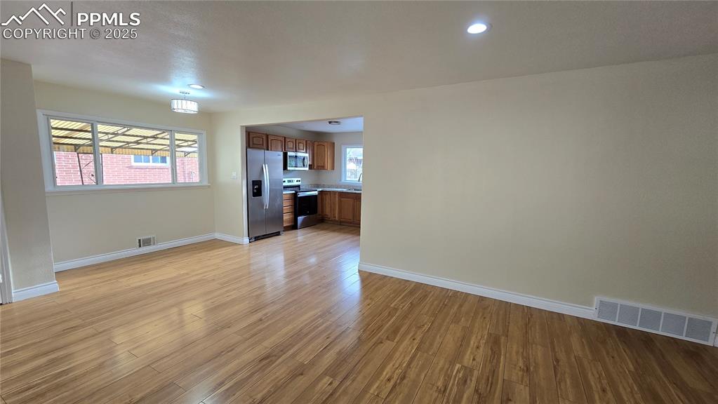 Image 5 of 42: Unfurnished living room with baseboards, light wood-type flooring, and rece