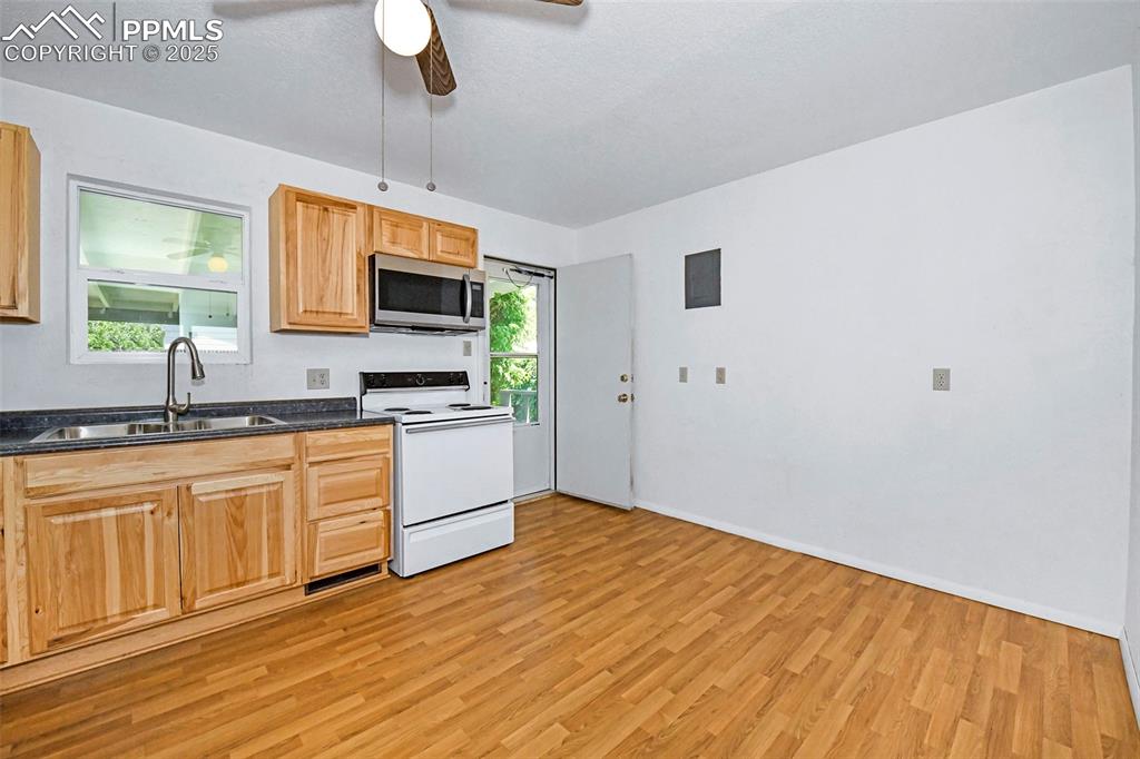 Image 5 of 19: Walk-out kitchen with large kitchen sink and view of backyard