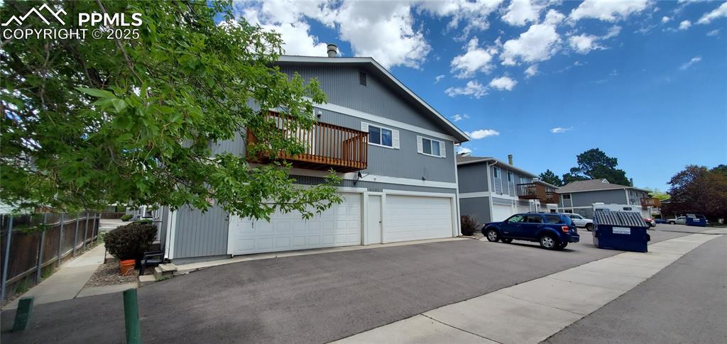 Image 2 of 7: Traditional-style home with a balcony, an attached garage, and a residentia