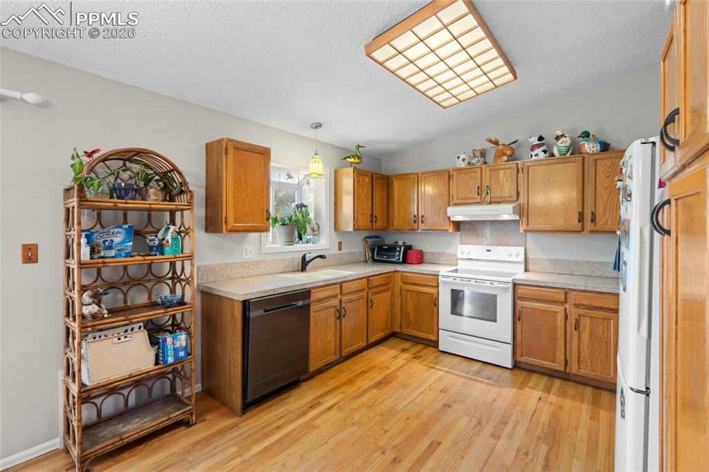 Image 6 of 27: Gleaming oak hardwood floors and flat panel oak cabinets. Newer dishwasher.