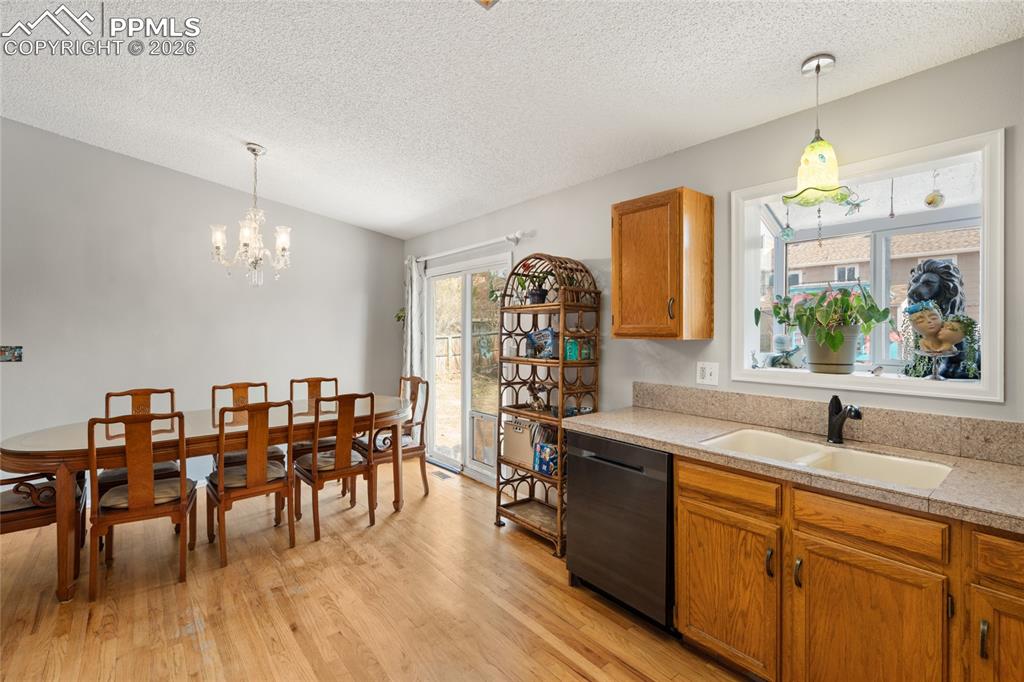 Image 8 of 27: View from kitchen into the dining area. Pretty plant window over the sink.