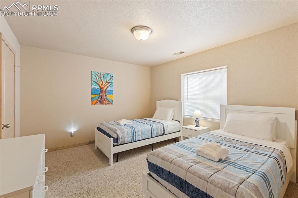 Image 21 of 27: Bedroom with light carpet and a textured ceiling