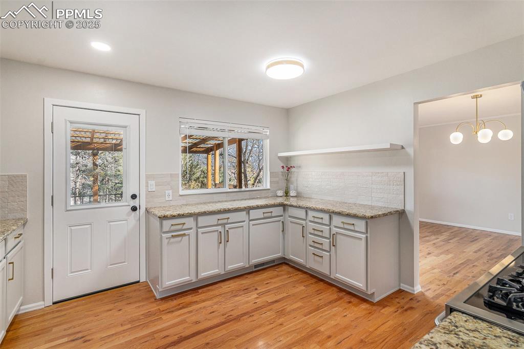 Image 4 of 26: REMODELLED KITCHEN with Walkout to Covered Deck and Views to Your Private B