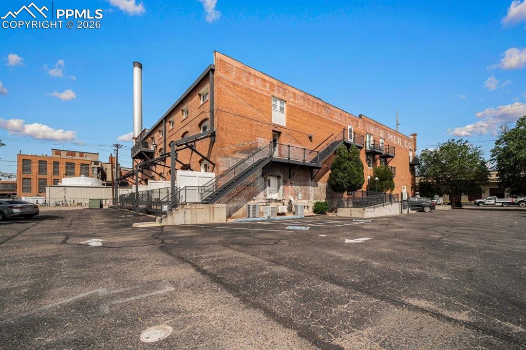 Image 1 of 32: View of building exterior featuring uncovered parking
