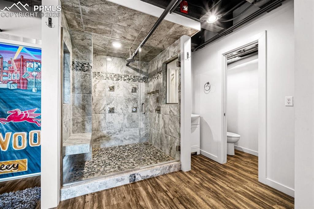 Image 24 of 32: Full bath with a shower stall and wood finished floors