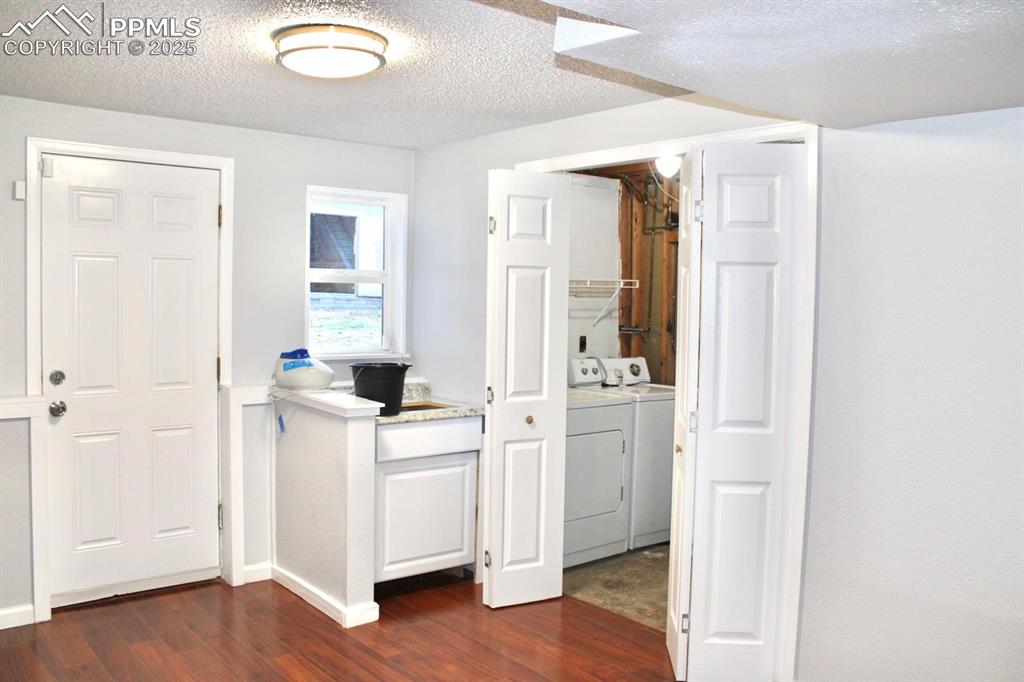 Image 14 of 15: Foyer entrance with washing machine and dryer, dark wood-type flooring, and