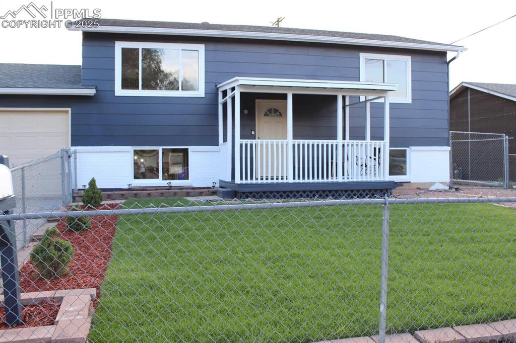 Image 3 of 15: View of front facade featuring covered porch and an attached garage