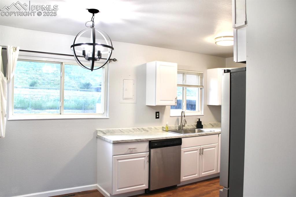 Image 8 of 15: Kitchen with appliances with stainless steel finishes, a chandelier, light 