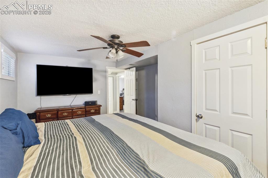 Image 13 of 17: Bedroom featuring a textured ceiling and ceiling fan