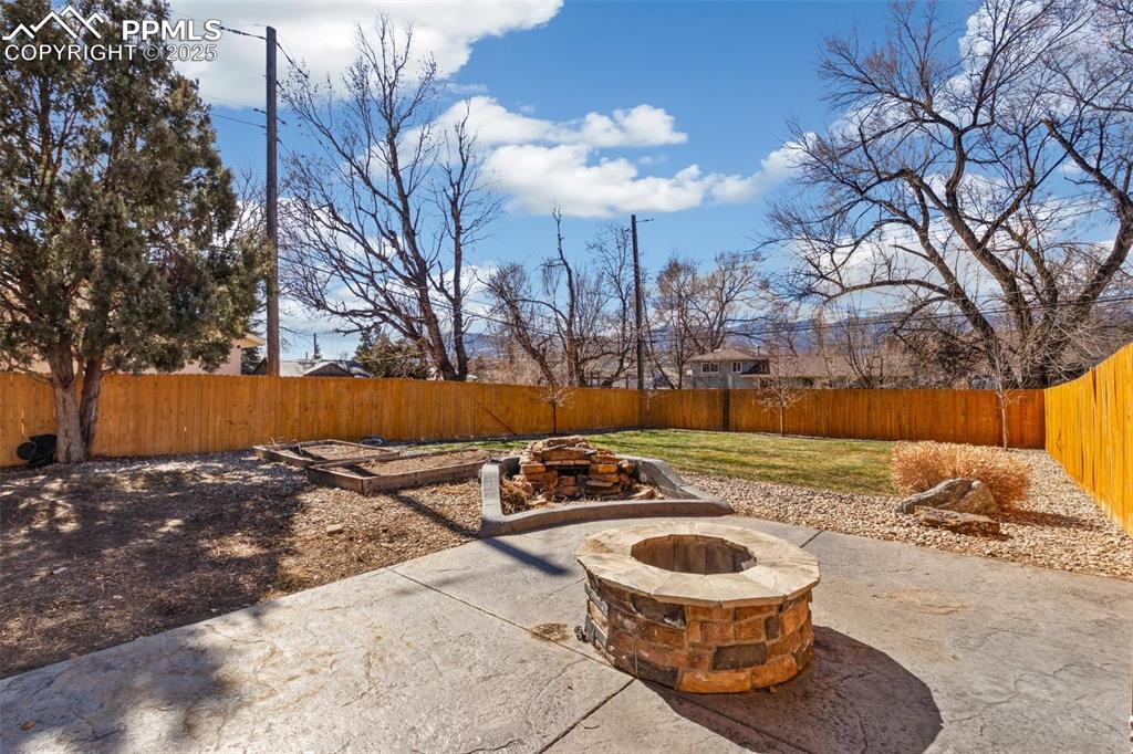 Image 15 of 17: Fenced backyard featuring a patio area and an outdoor fire pit