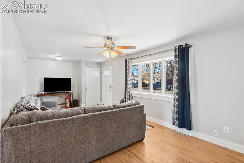 Image 3 of 17: Living area with wood finished floors and a ceiling fan