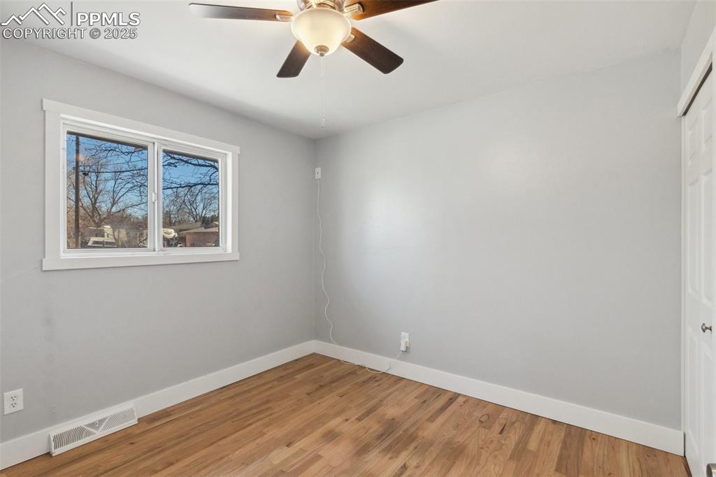 Image 8 of 17: Spare room with wood finished floors and ceiling fan