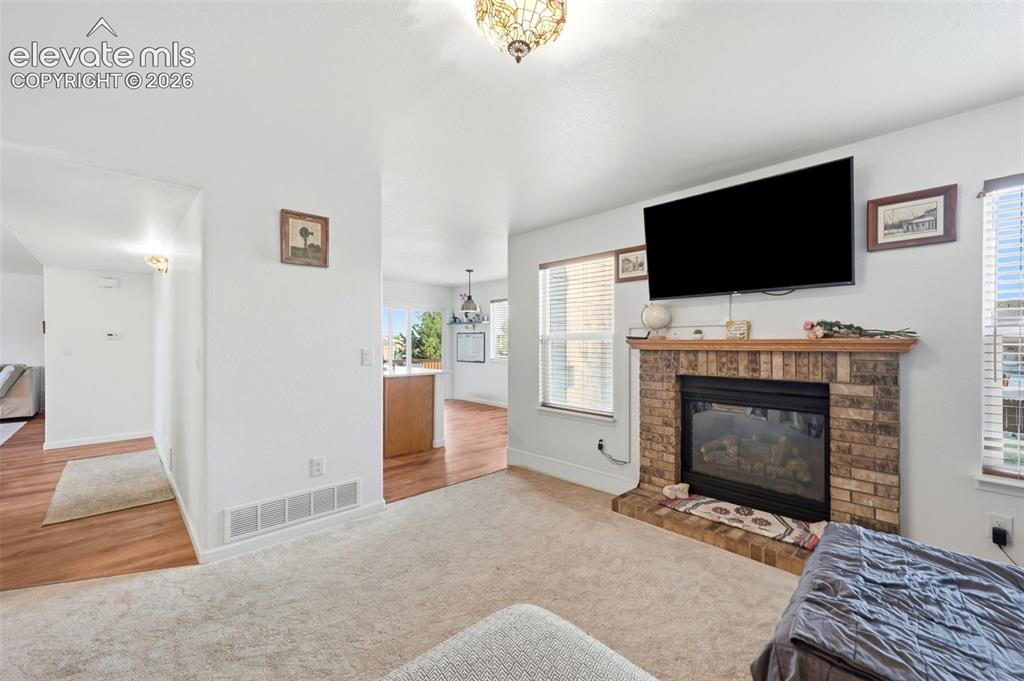 Image 13 of 40: Brick-clad fireplace with a wood mantel