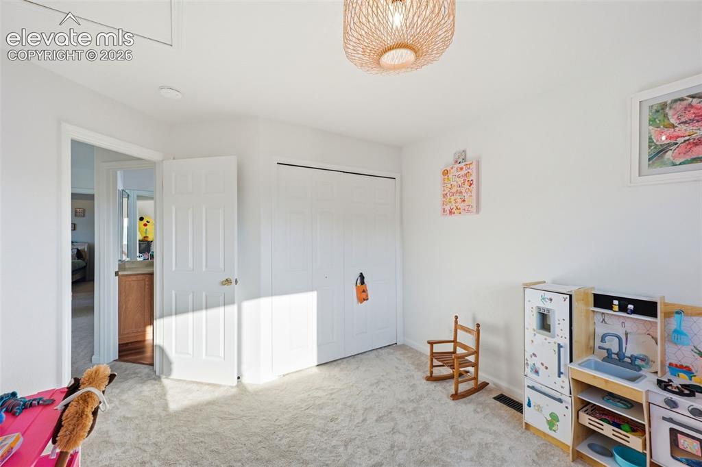 Image 17 of 40: Carpeted flooring, white walls, and a light fixture