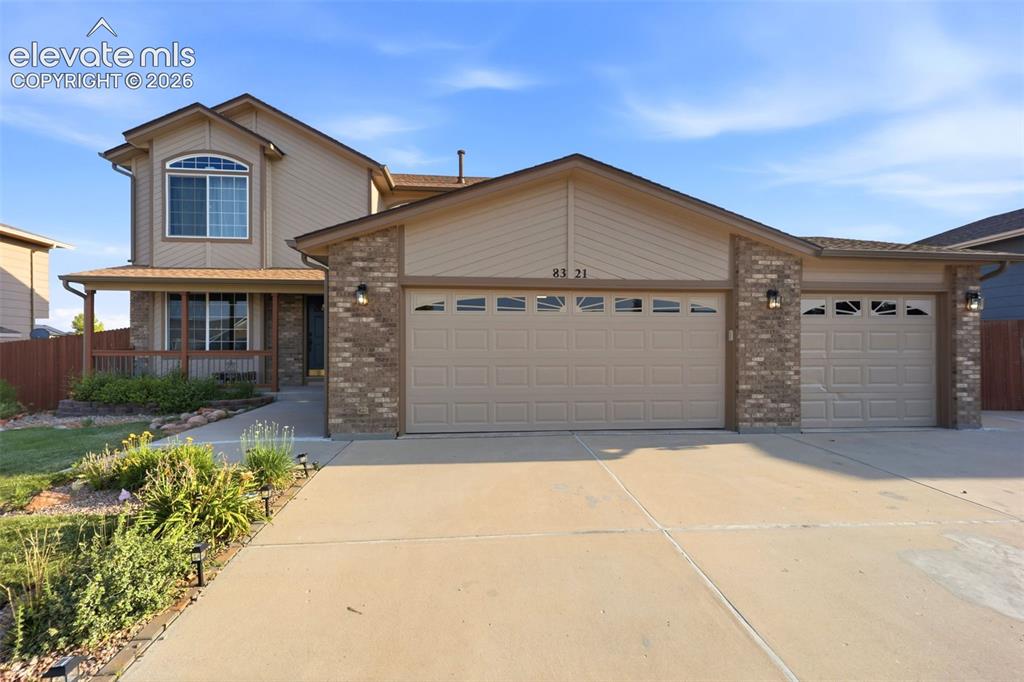 Image 2 of 40: Exterior featuring a covered porch, brick accents, concrete driveway, and a