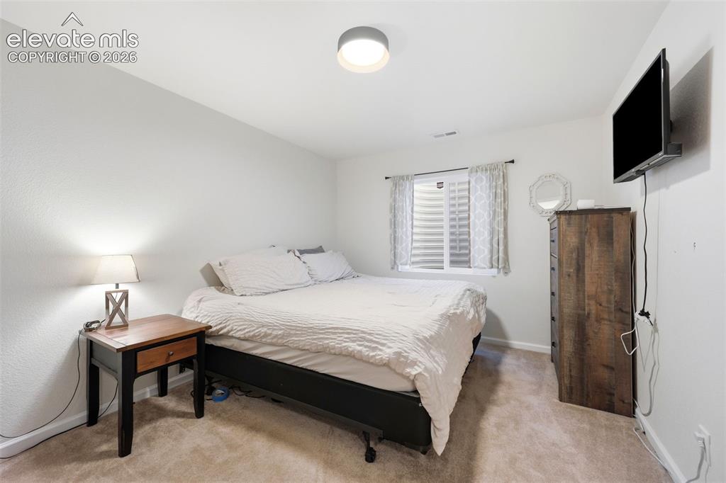 Image 25 of 40: Recessed egress window with white blinds, neutral carpet flooring, and a fl