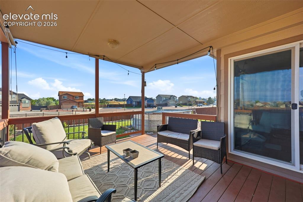 Image 28 of 40: Covered outdoor deck with wood-finish flooring