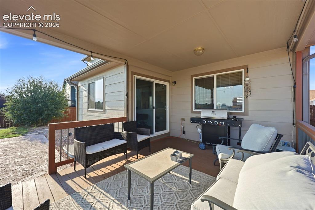 Image 29 of 40: Covered deck with wood-finish flooring, featuring a sliding glass door and 