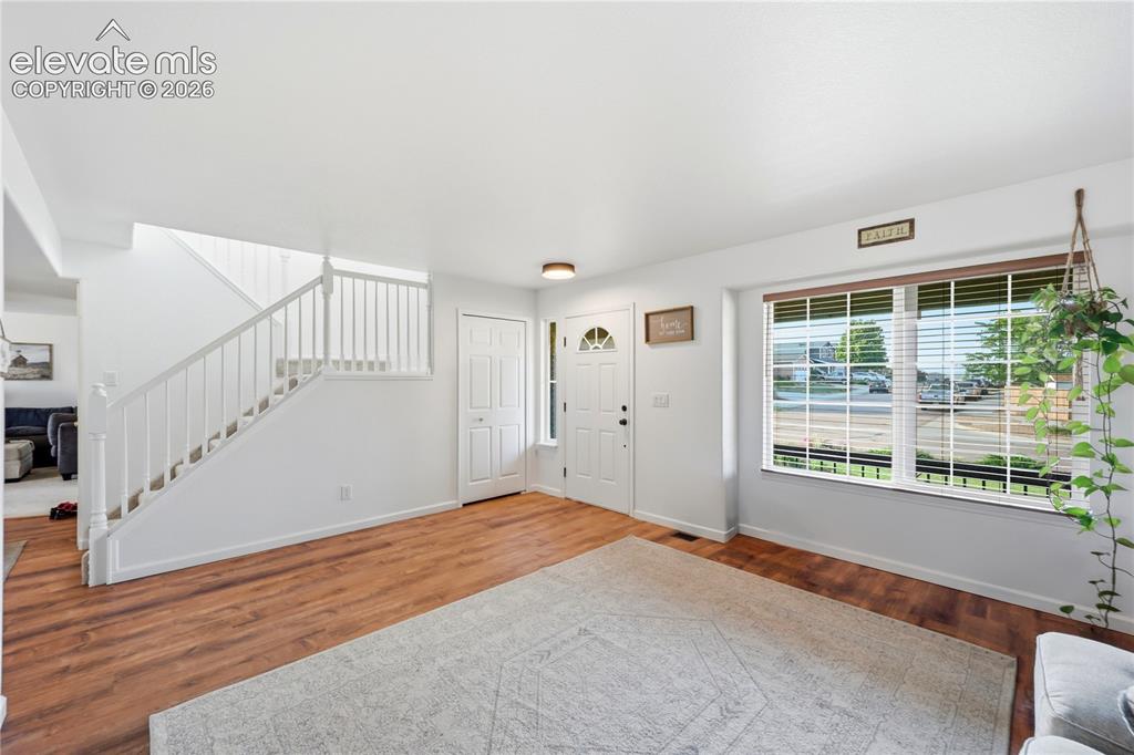 Image 3 of 40: Hardwood-finish flooring, white painted walls, white spindle staircase, whi