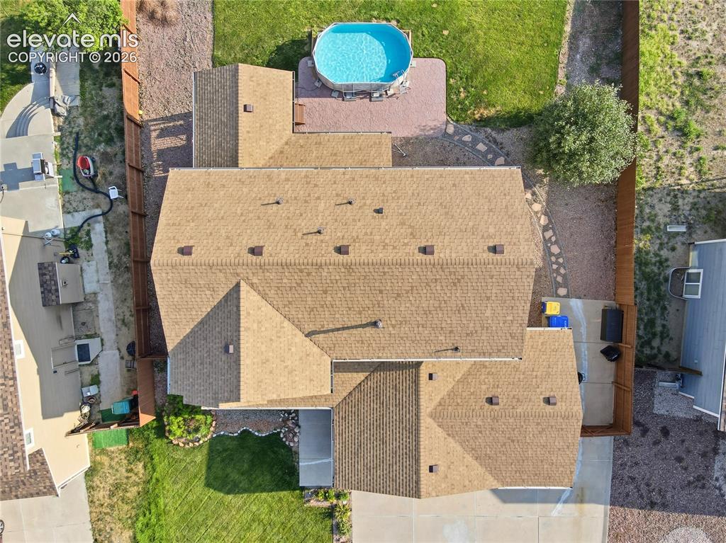 Image 35 of 40: Gabled roofline with asphalt shingles, fenced backyard, and an above-ground