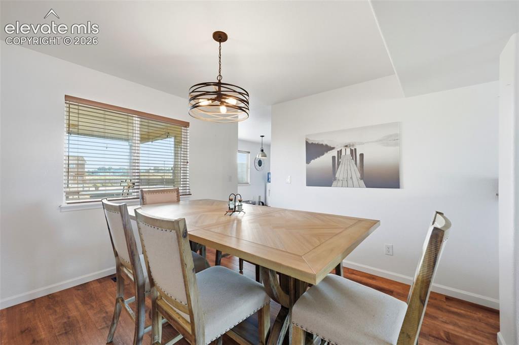 Image 6 of 40: Wood-finish flooring with crisp white walls and a contemporary chandelier
