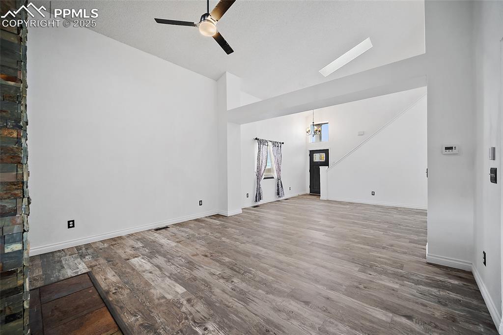 Image 11 of 50: Unfurnished living room with light wood-style flooring, a ceiling fan, and 