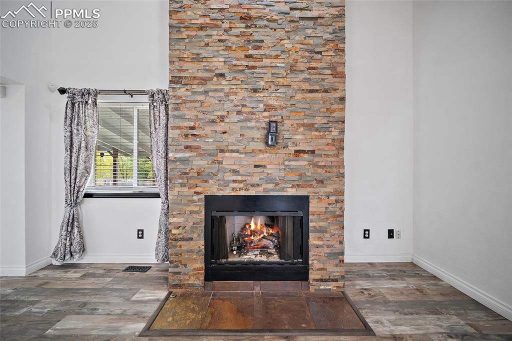 Image 13 of 50: Detailed view of a lit fireplace and wood finished floors