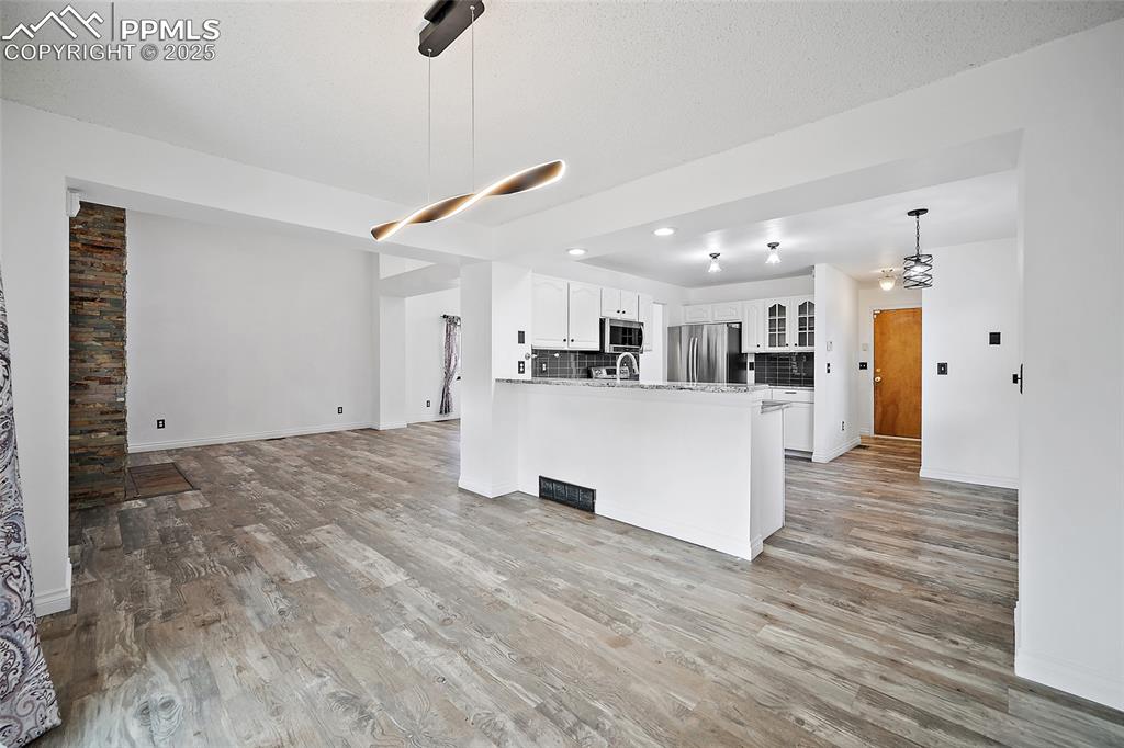 Image 16 of 50: Kitchen featuring open floor plan, decorative light fixtures, a peninsula, 