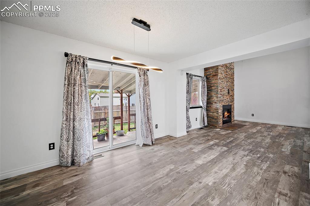 Image 17 of 50: Unfurnished living room featuring a textured ceiling, wood finished floors,
